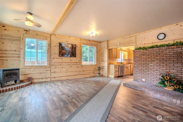 a spacious bedroom with a bed and a dresser with wooden floor
