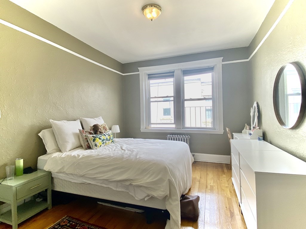1691 Commonwealth Avenue, Unit 31 Boston, MA 02135 - Photo 6 of 12 a bedroom with a bed and a dresser next to a window
