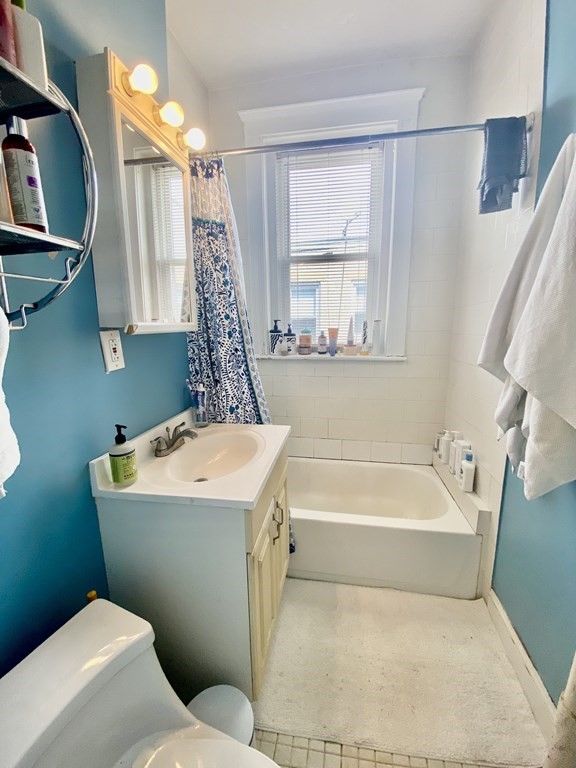 1691 Commonwealth Avenue, Unit 31 Boston, MA 02135 - Photo 7 of 12 a bathroom with a sink a toilet a tub and shower