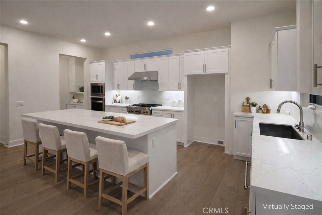 2173 Swaim Way Tustin, CA 92782 - Photo 11 of 34 a kitchen with kitchen island a stove a table and chairs