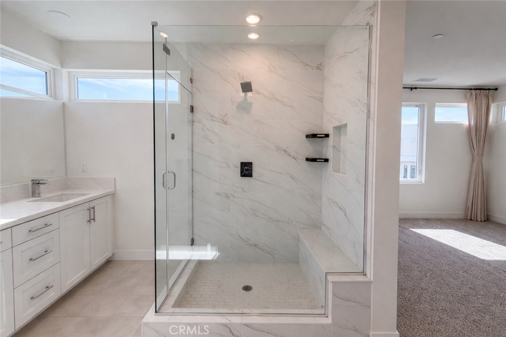 2173 Swaim Way Tustin, CA 92782 - Photo 22 of 34 a bathroom with a shower sink vanity and mirror