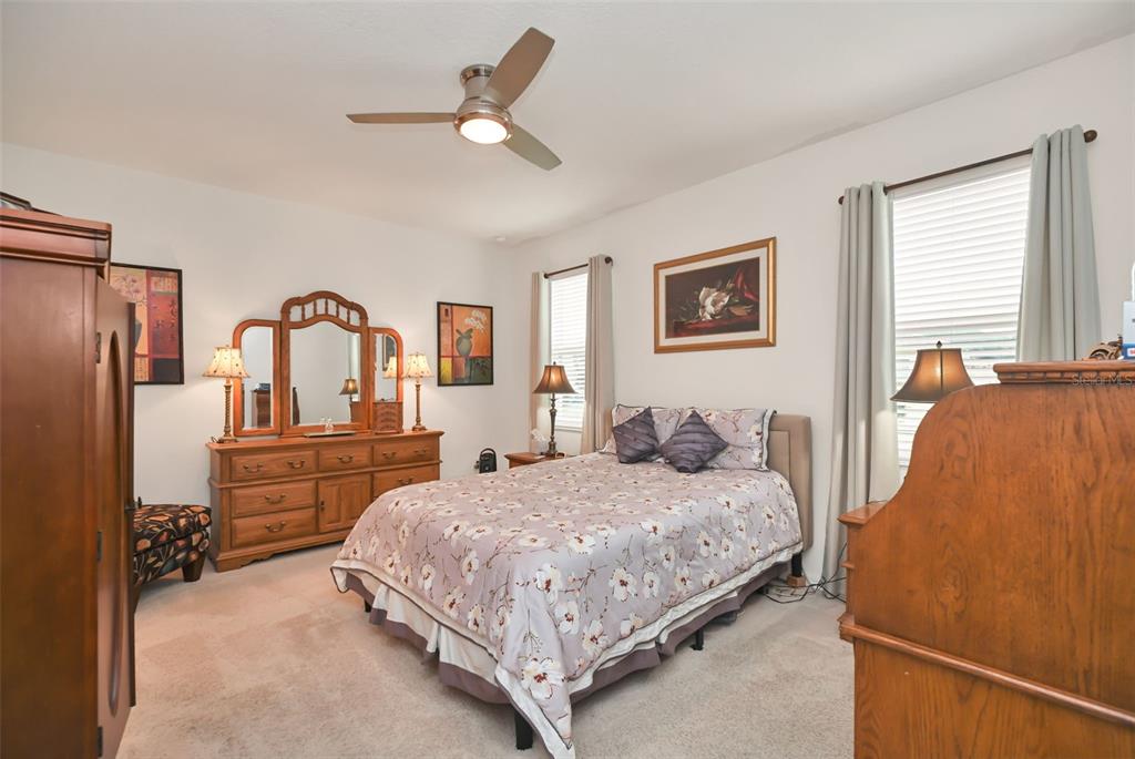 8237 Southwest 78th Terrace Road Ocala, FL 34476 - Photo 12 of 22 a bedroom with a large bed and a chandelier