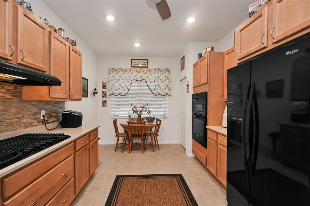 8237 Southwest 78th Terrace Road Ocala, FL 34476 - Photo 6 of 22 a kitchen with stainless steel appliances granite countertop a stove top oven a sink dishwasher and cabinets with wooden floor
