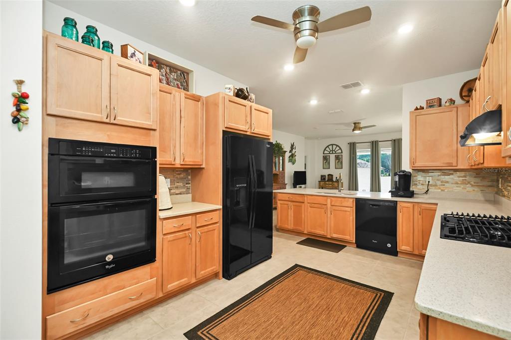8237 Southwest 78th Terrace Road Ocala, FL 34476 - Photo 7 of 22 a kitchen with stainless steel appliances wooden floor sink and wooden cabinets