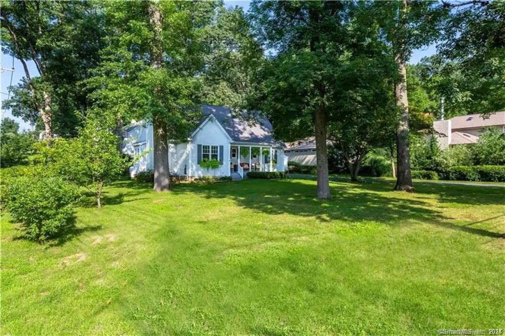 9 Beech Street Farmington, CT 06032 - Photo 2 of 37 a front view of a house with a yard table and chairs