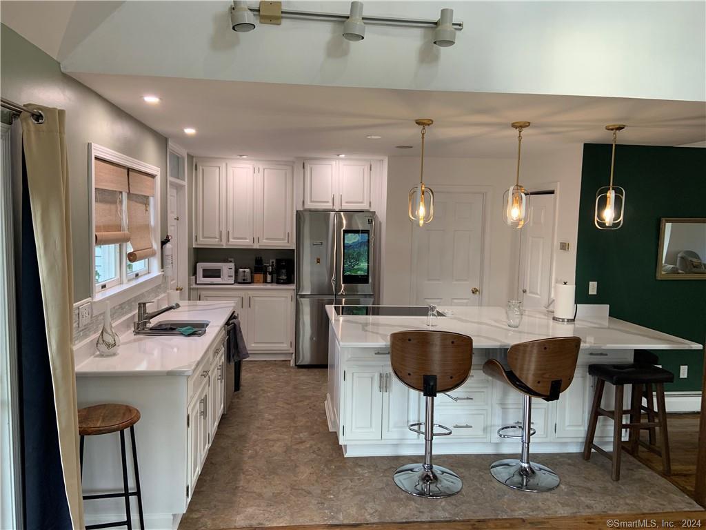 9 Beech Street Farmington, CT 06032 - Photo 6 of 37 a kitchen with a dining table chairs sink and cabinets