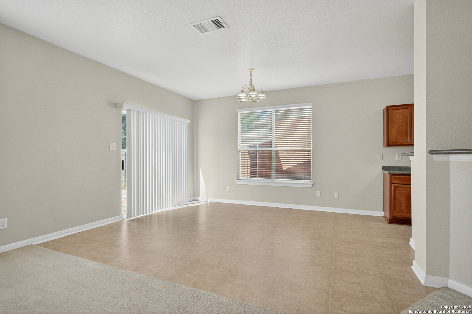 221 Springtree Cove Cibolo, TX 78108 - Photo 13 of 33 an empty room with windows and chandelier fan