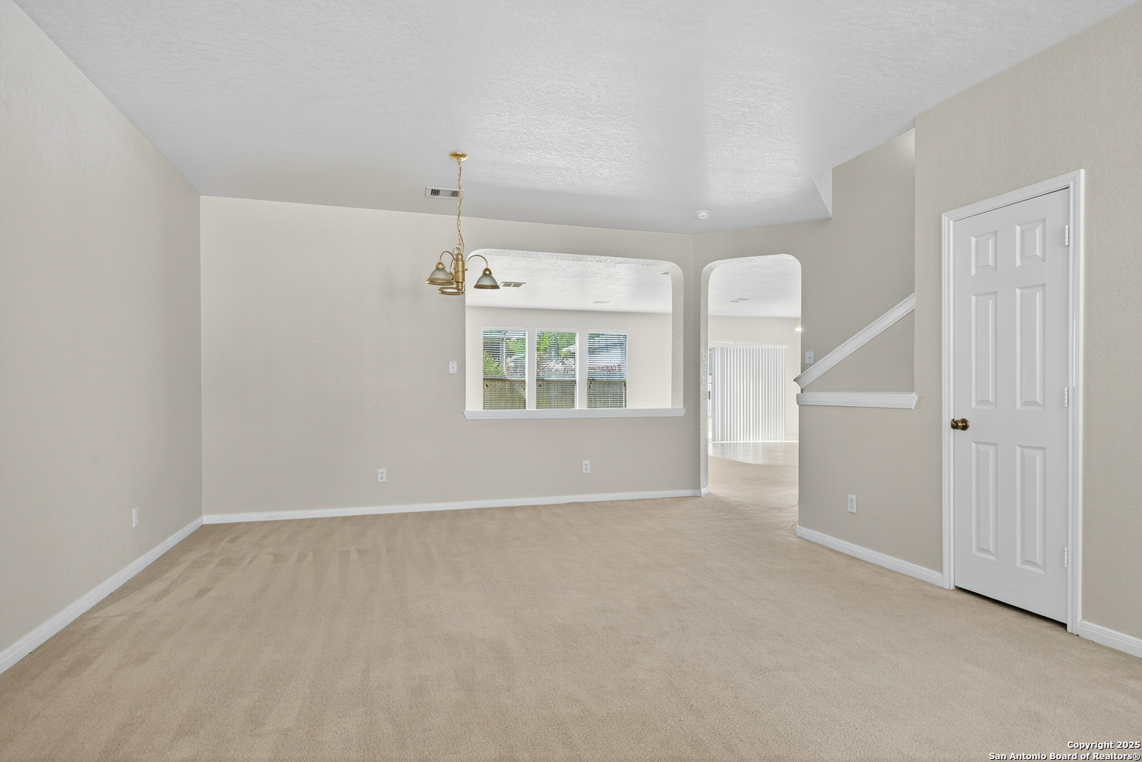 221 Springtree Cove Cibolo, TX 78108 - Photo 16 of 33 an empty room with windows and chandelier fan
