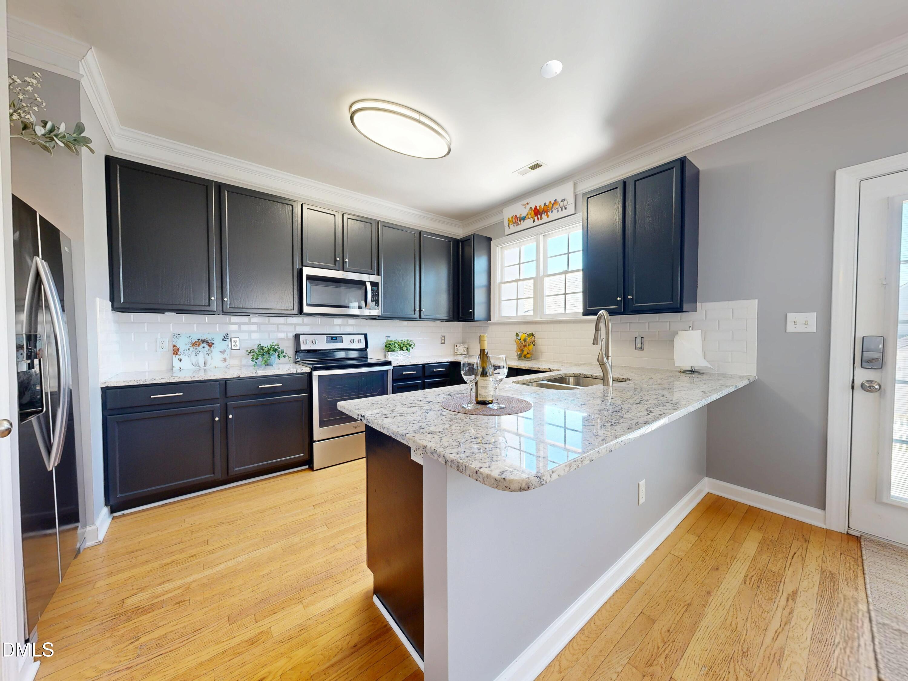 200 Madison Grove Place Cary, NC 27519 - Photo 13 of 49 a kitchen with stainless steel appliances granite countertop a sink stove and refrigerator