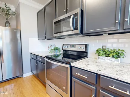 a kitchen with a granite countertop kitchen island a sink stainless steel appliances and cabinets