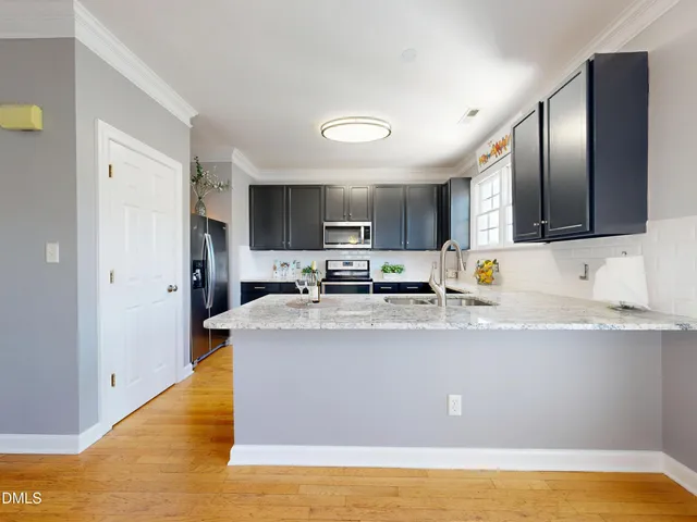 a kitchen with stainless steel appliances granite countertop a refrigerator and a microwave