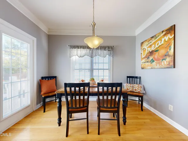 a dining room with furniture a chandelier and wooden floor