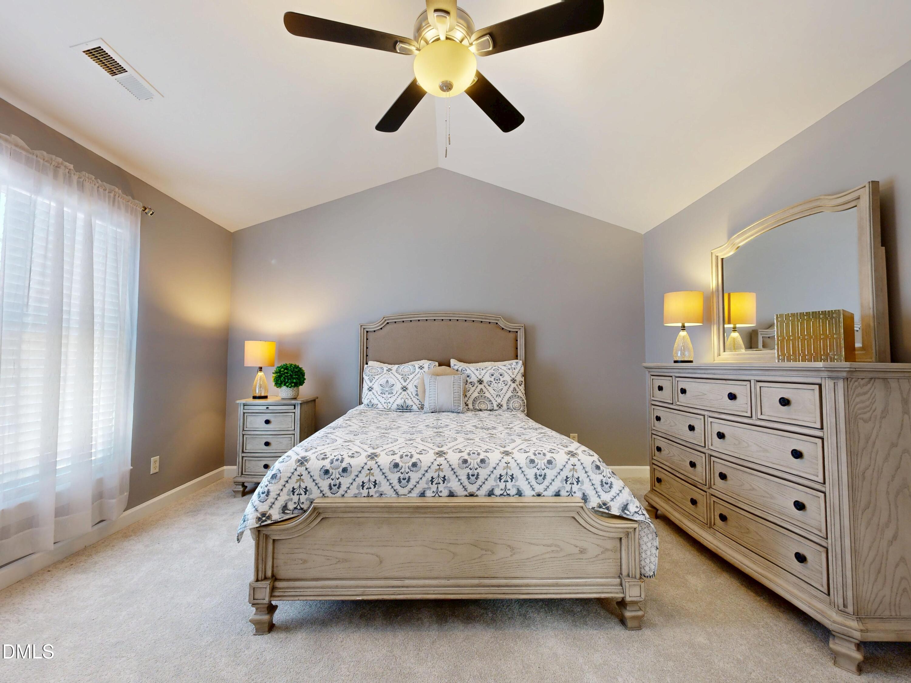 200 Madison Grove Place Cary, NC 27519 - Photo 19 of 49 a bedroom with a bed a lamp and a flat tv screen