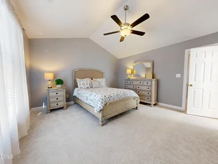 a spacious bedroom with a bed and painting on the wall