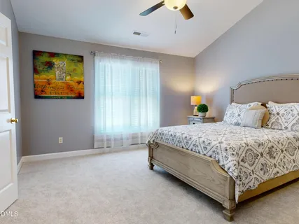 a bedroom with a bed a lamp and a flat tv screen