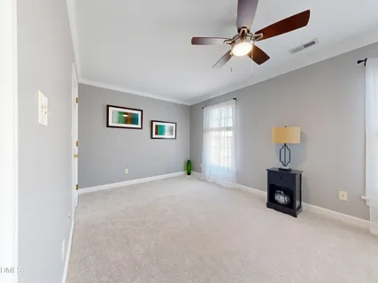 a view of a livingroom with a ceiling fan & a window