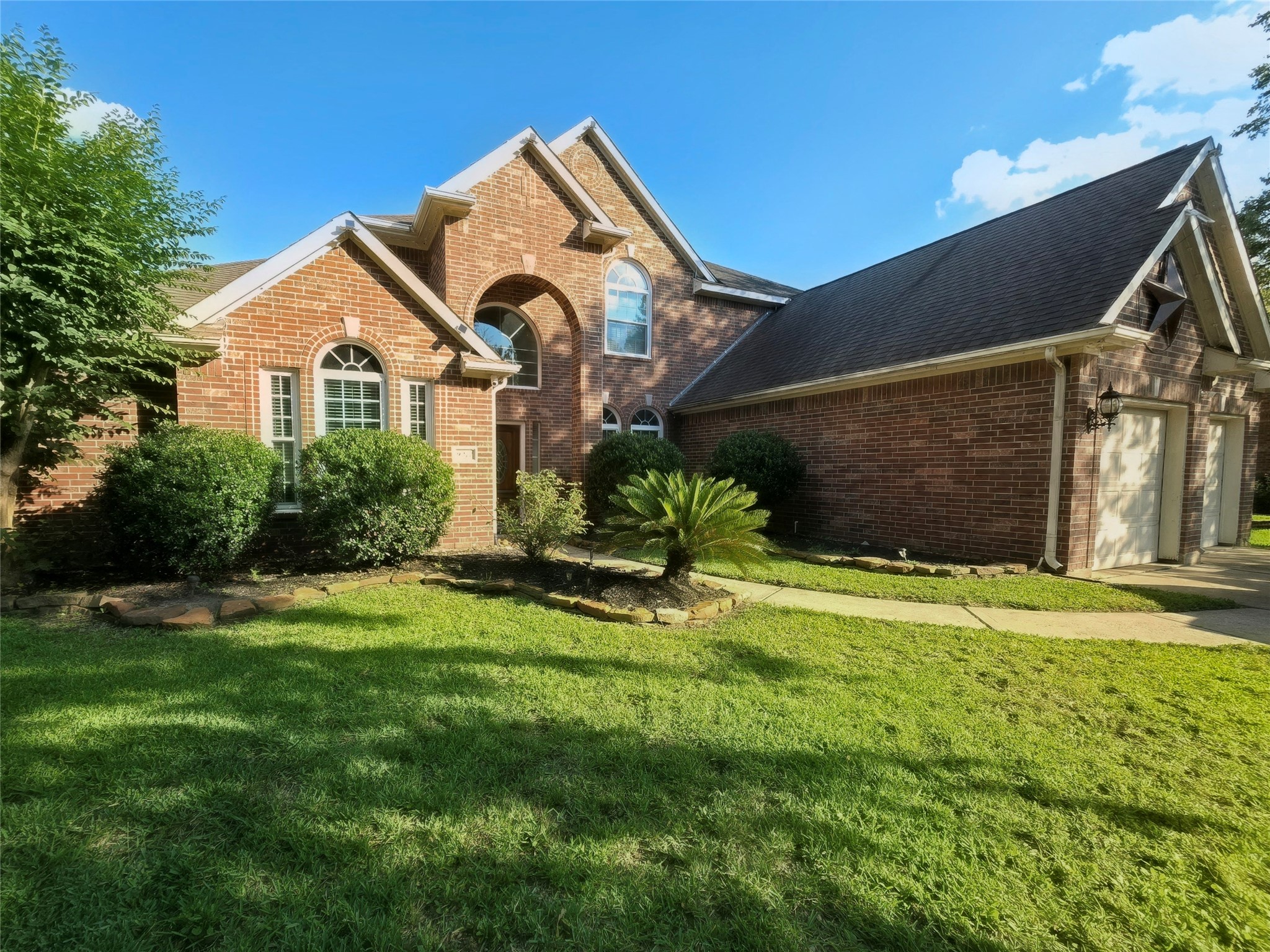 9211 Memorial Grove Drive Spring, TX 77379 - Photo 2 of 38 a front view of a house with a yard and garage
