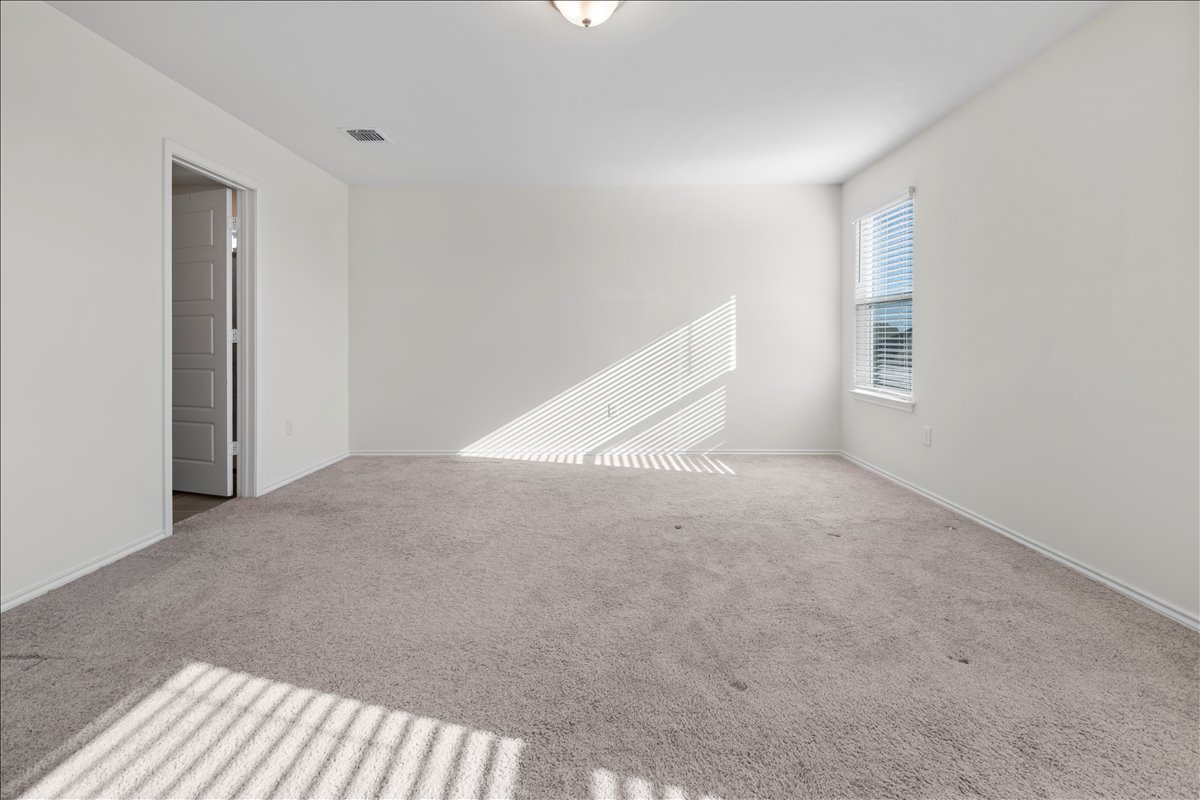 18501 Spotted Eagle Lane Elgin, TX 78621 - Photo 26 of 40 A well-lit, neutral-toned room ready for your personal touch and furnishing.