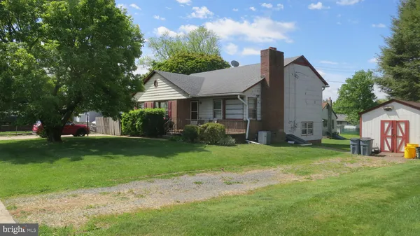 a view of a house with a big yard plants and large trees