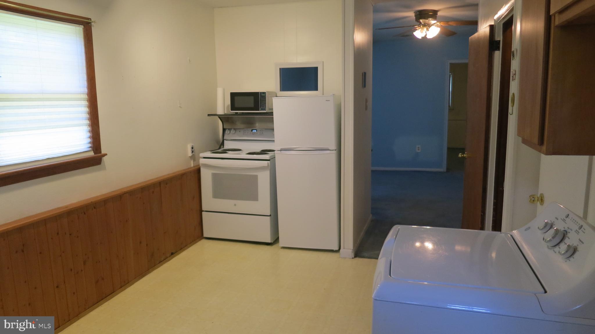 79 Ewingville Road Ewing, NJ 08638 - Photo 30 of 67 a kitchen with stainless steel appliances a refrigerator a stove a microwave oven with white cabinets and wooden floor