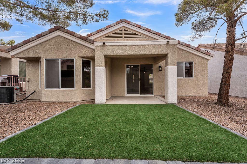 2139 Chapman Ranch Drive Henderson, NV 89012 - Photo 6 of 58 A well-maintained backyard with artificial turf and a covered patio for outdoor enjoyment.