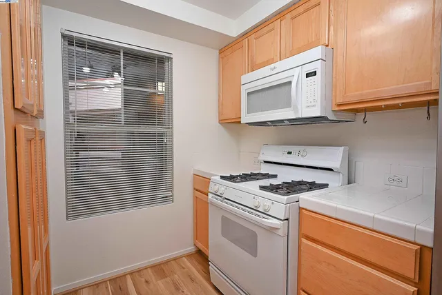a kitchen with granite countertop cabinets stainless steel appliances and a window