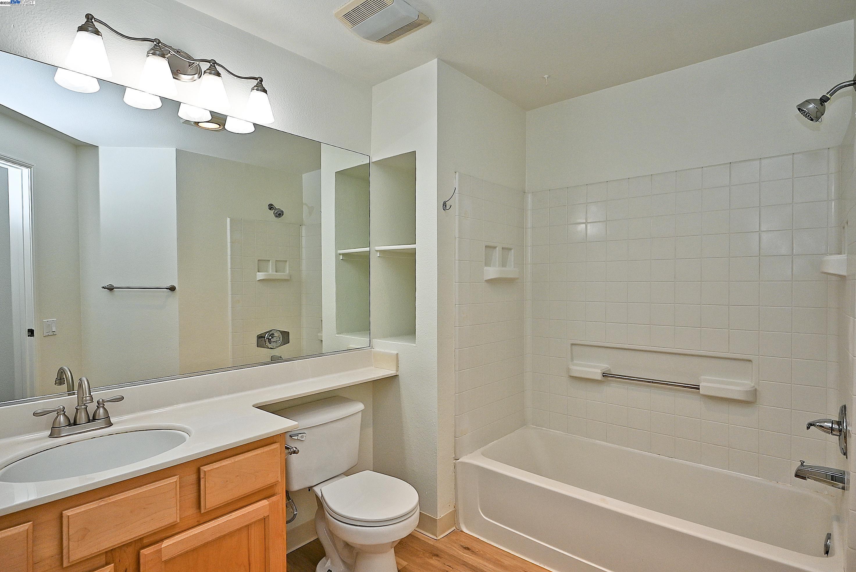280 Caldecott Lane, Unit 221 Oakland, CA 94618 - Photo 16 of 31 a bathroom with a granite countertop sink a toilet and shower
