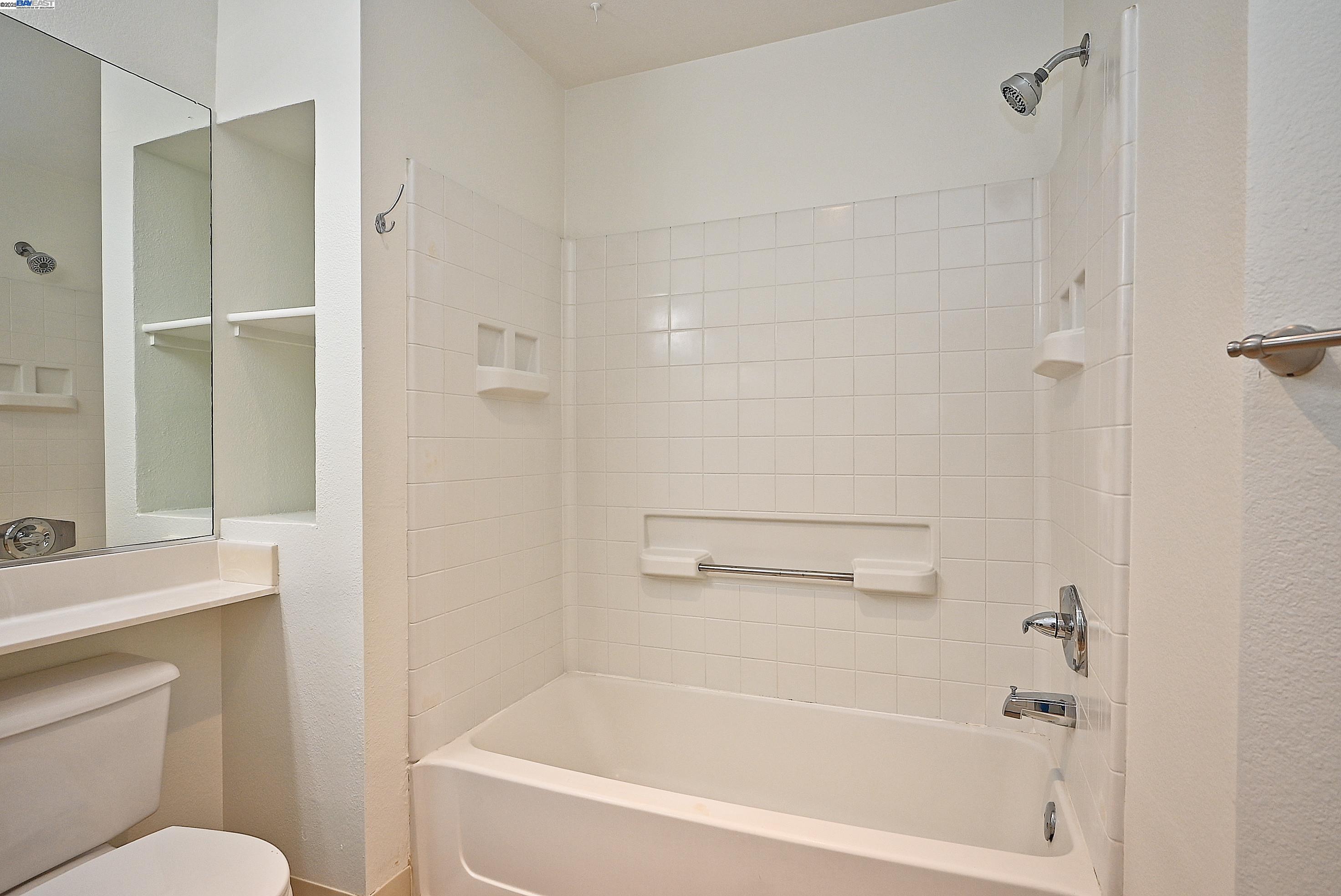 280 Caldecott Lane, Unit 221 Oakland, CA 94618 - Photo 19 of 31 a white bath tub sitting next to a white toilet and a shower