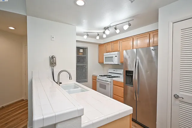 a kitchen with stainless steel appliances a refrigerator sink and stove