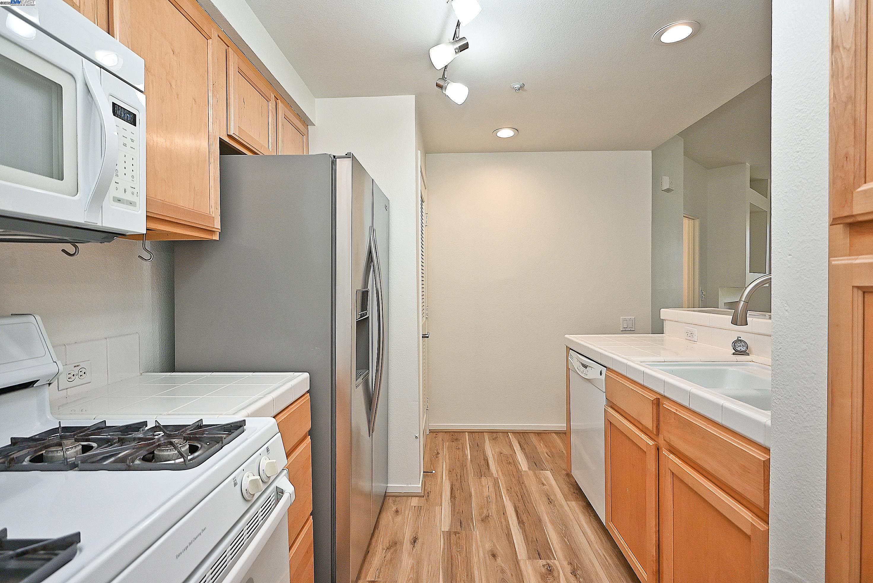 280 Caldecott Lane, Unit 221 Oakland, CA 94618 - Photo 10 of 31 a kitchen with stainless steel appliances granite countertop a sink stove and refrigerator
