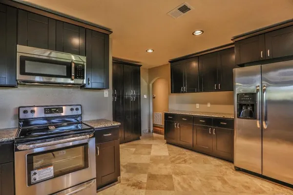 a kitchen with stainless steel appliances granite countertop a refrigerator and a sink