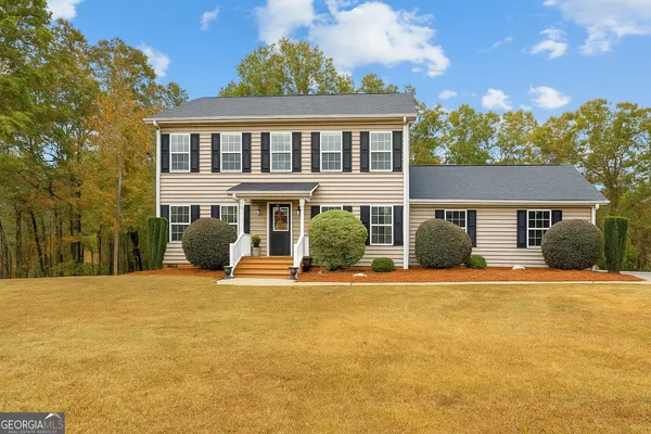 a front view of a house with a yard and trees