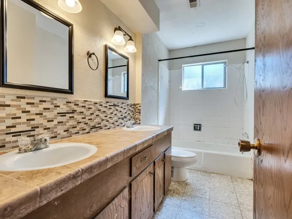 an empty room with windows and ceiling fan