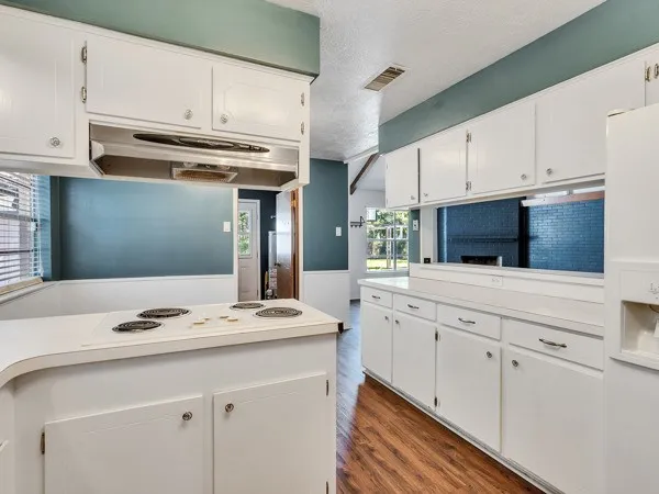 a kitchen with granite countertop a sink cabinets and stainless steel appliances