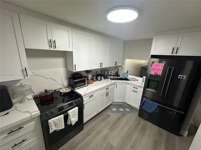 a kitchen with a sink cabinets and wooden floor