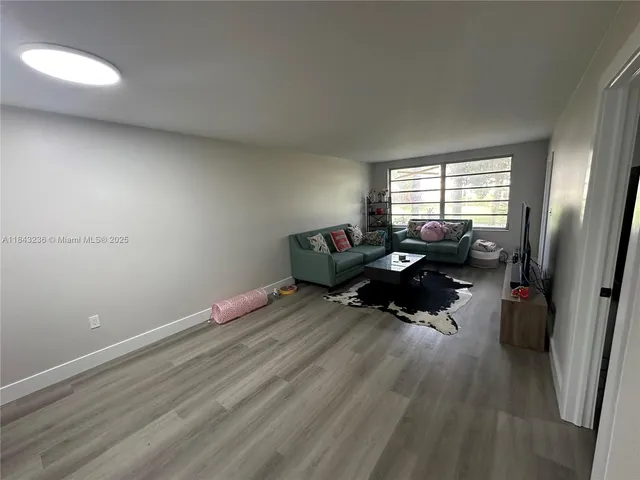 a living room with furniture window and wooden floor