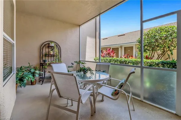 a dining room with furniture and a potted plant