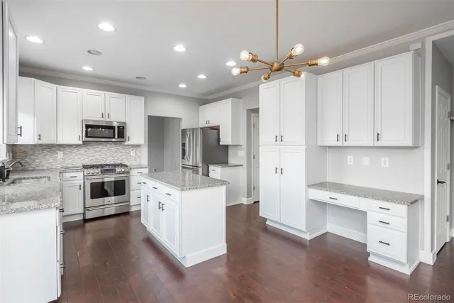 a large white kitchen with stainless steel appliances