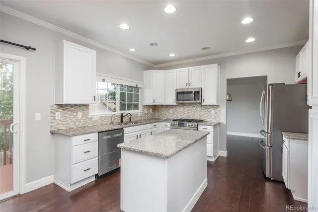 a kitchen with white cabinets and stainless steel appliances
