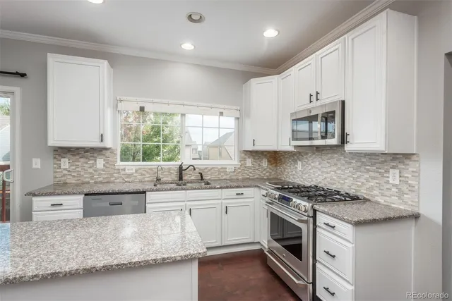 a kitchen with stainless steel appliances granite countertop a sink stove and cabinets