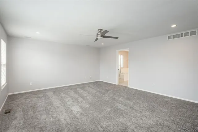 an empty room with a ceiling fan and window
