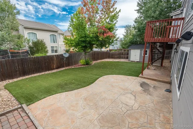 a view of backyard of house and wooden deck