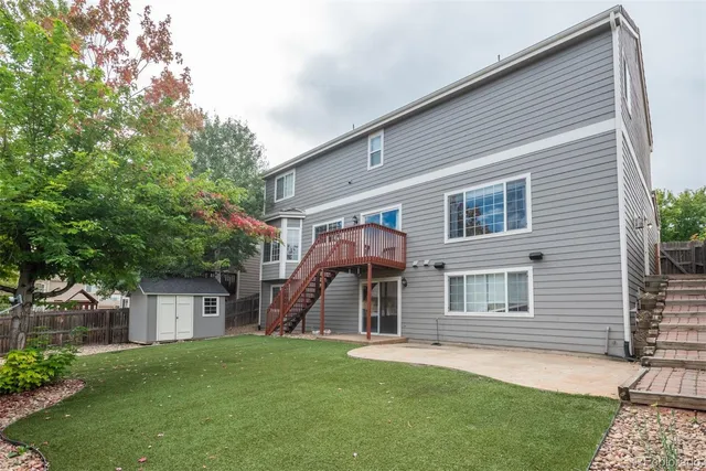 a view of an house with backyard and a tree