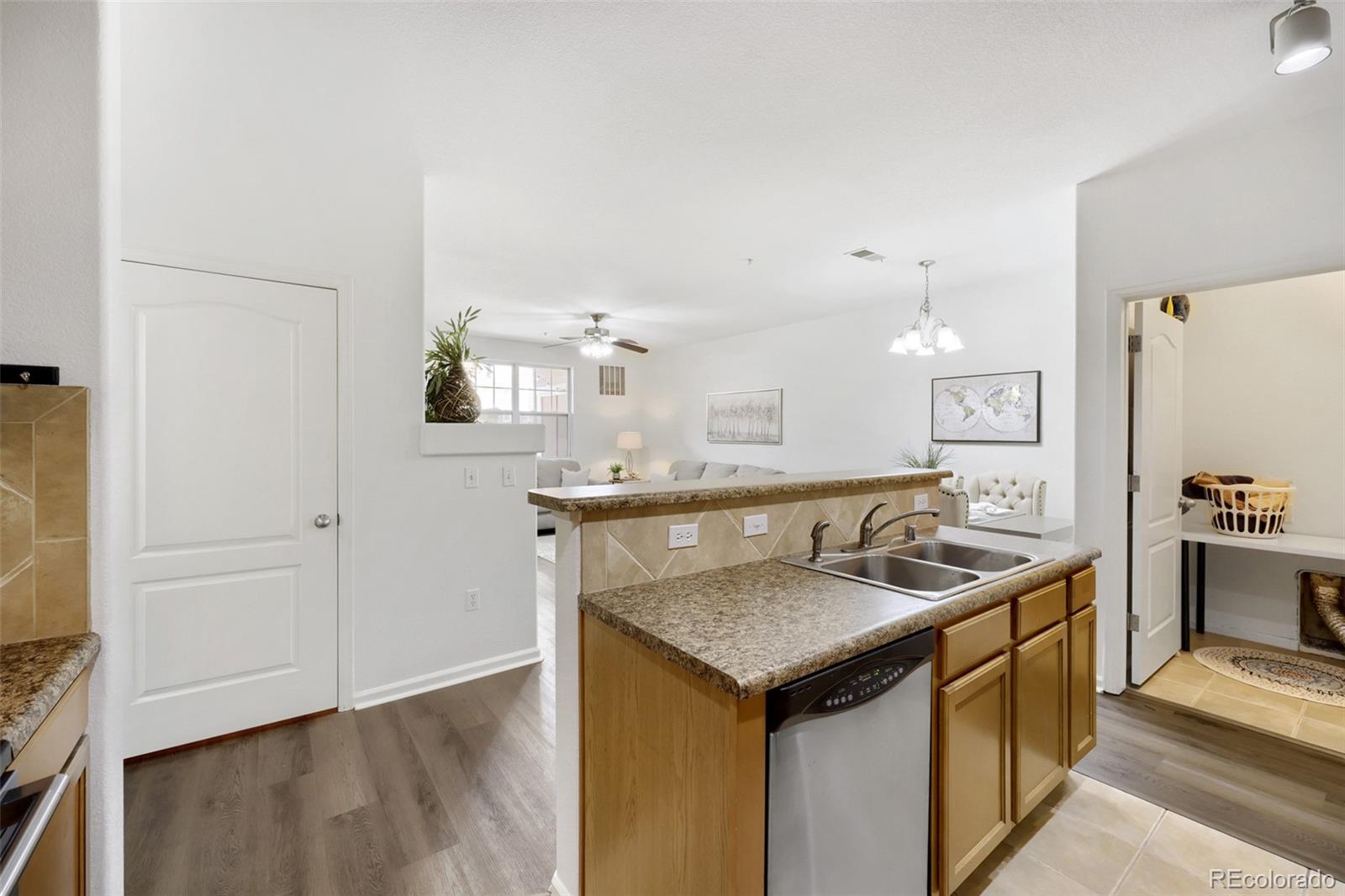 7130 Simms Street, Unit 107 Arvada, CO 80004 - Photo 12 of 29 a kitchen with stainless steel appliances granite countertop a sink and a stove