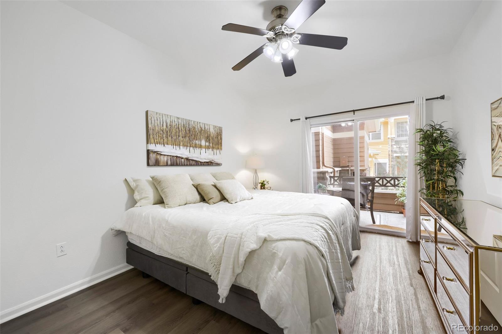 7130 Simms Street, Unit 107 Arvada, CO 80004 - Photo 13 of 29 a bedroom with a large bed and a chandelier