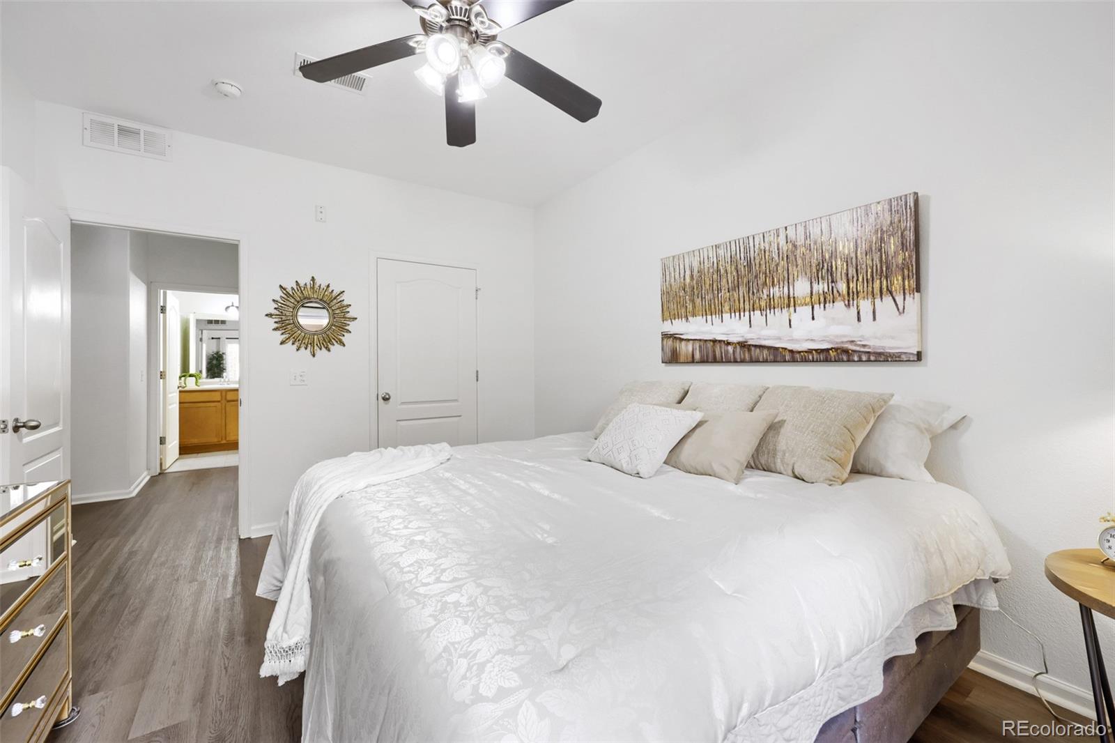 7130 Simms Street, Unit 107 Arvada, CO 80004 - Photo 14 of 29 a bedroom with a bed and a chandelier