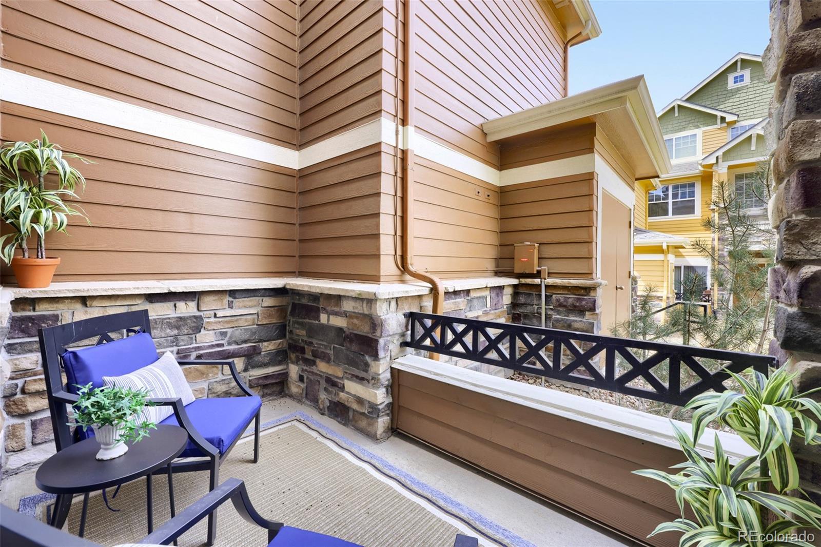 7130 Simms Street, Unit 107 Arvada, CO 80004 - Photo 16 of 29 a view of a patio with table and chairs with wooden floor and plants