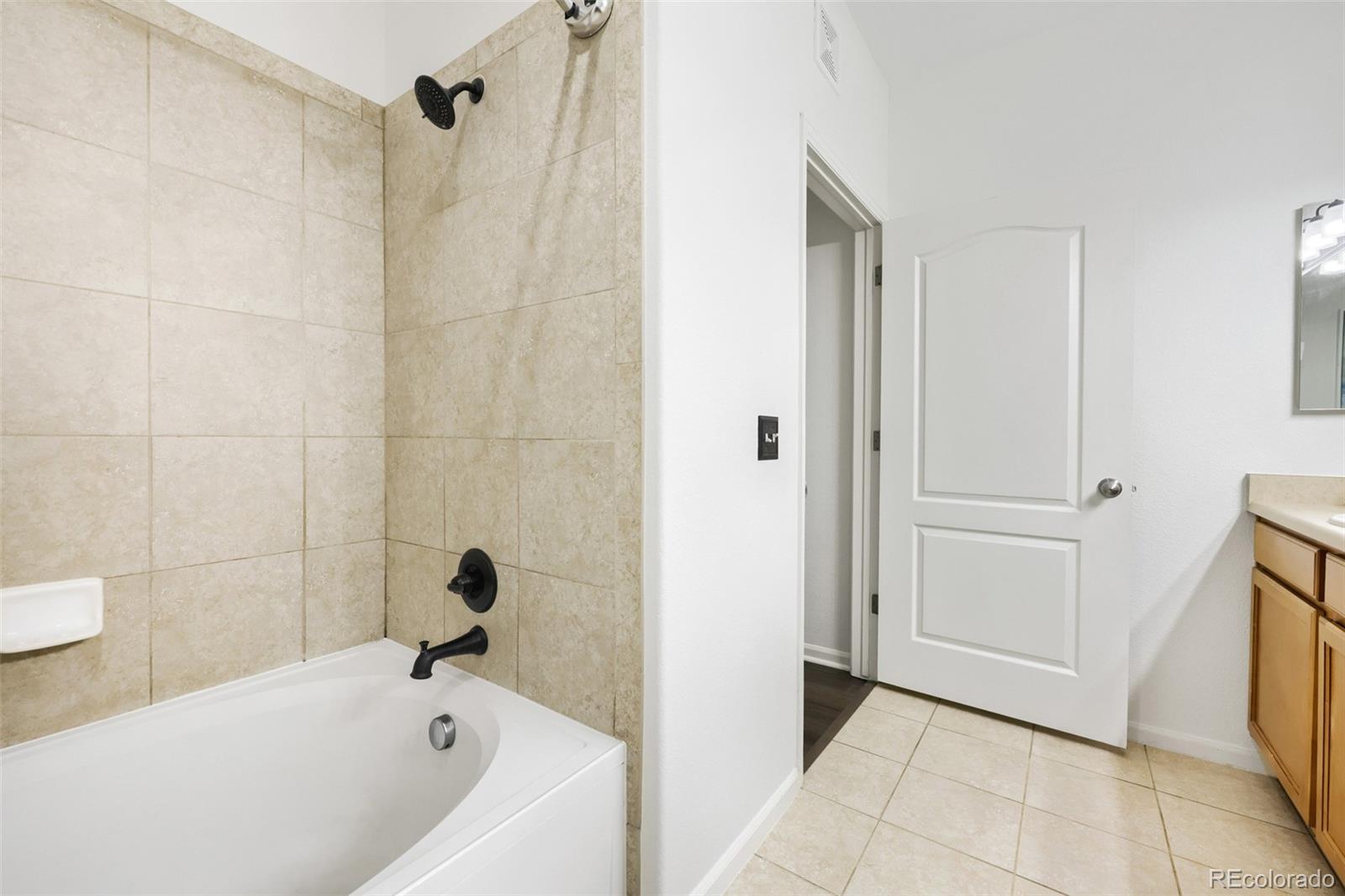 7130 Simms Street, Unit 107 Arvada, CO 80004 - Photo 19 of 29 a bathroom with a tub and a shower