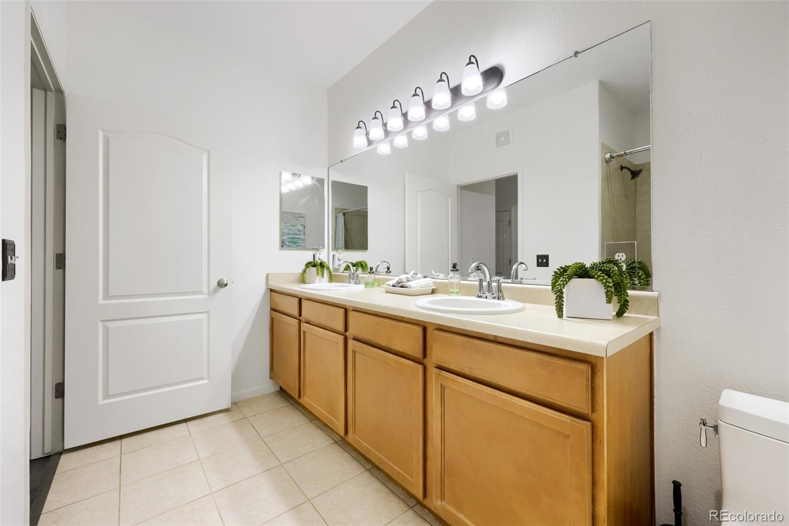 7130 Simms Street, Unit 107 Arvada, CO 80004 - Photo 20 of 29 a bathroom with a sink vanity and a mirror