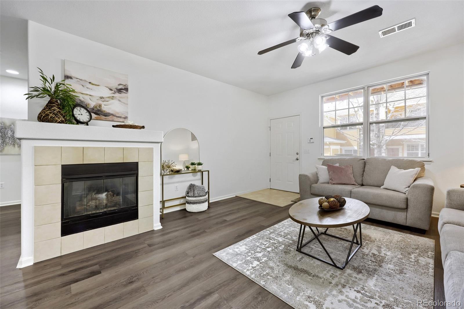 7130 Simms Street, Unit 107 Arvada, CO 80004 - Photo 4 of 29 a living room with furniture a window and a fireplace